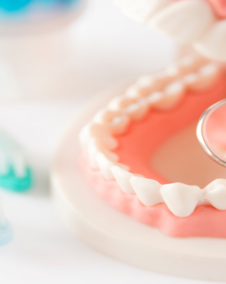 歯科医が子供の口の中を診て指さしている様子