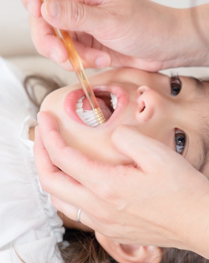 子どもが歯磨きをしてもらっている様子